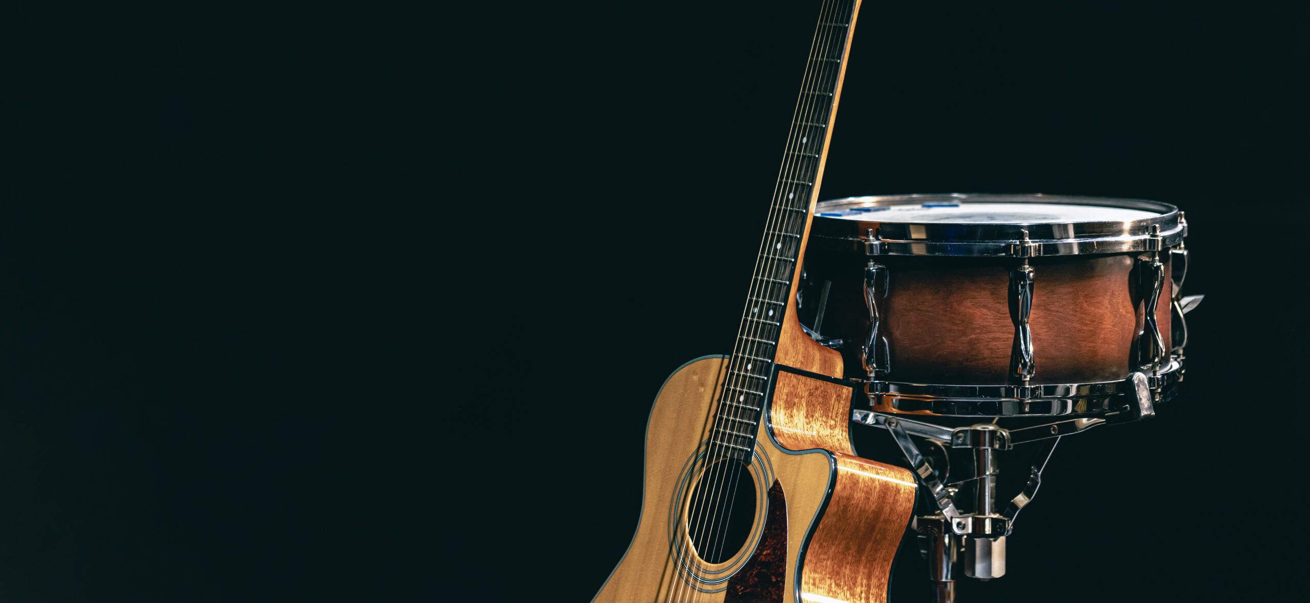 acoustic guitar and snare drum on a black background isolated.